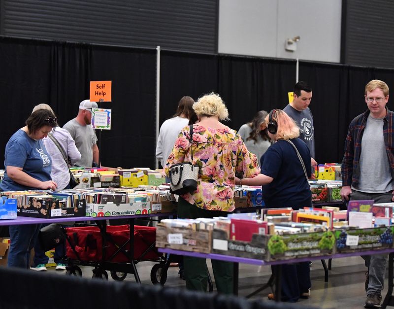 Guests walk through aisles of books during the Wichita Adult Literacy Council Book Fair inside the Multi-Purpose Event Center's Ray Clymer Exhibit Hall on Saturday, March 1, 2025.