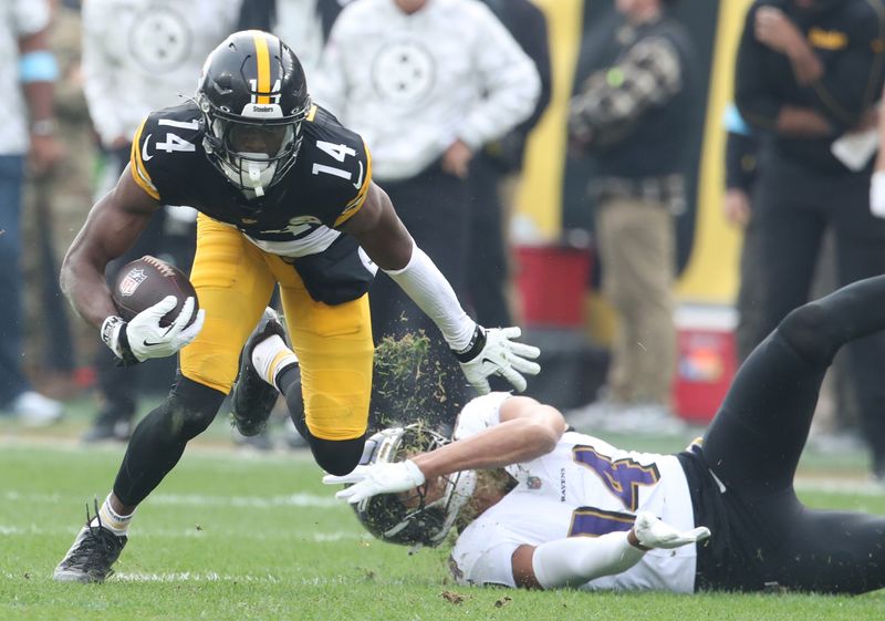Nov 17, 2024; Pittsburgh, Pennsylvania, USA; Pittsburgh Steelers wide receiver George Pickens (14) runs after a catch against Baltimore Ravens safety Kyle Hamilton (right) during the second quarter at Acrisure Stadium. Mandatory Credit: Charles LeClaire-Imagn Images