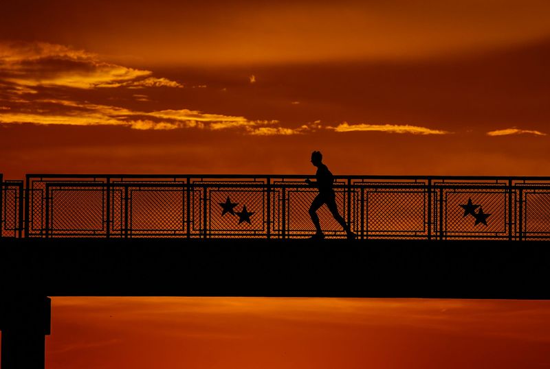 John Pittman crosses the bridge over Lake Pflugerville Dam on Wednesday, May 14, 2025. Central Texas continues to experience hot weather throughout the week.