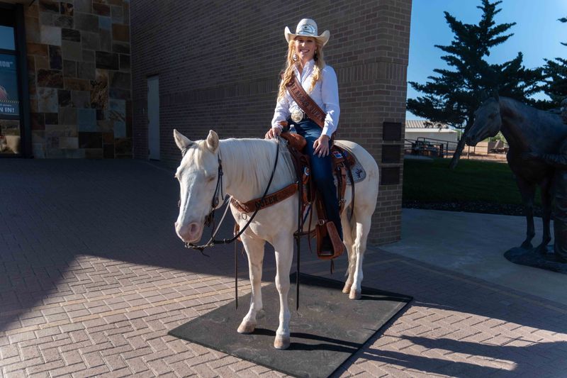 Sophia Latini, the reigning XIT Rodeo Queen, poses with her horse Cremalicious outside the American Quarter Horse Hall of Fame & Museum on May 16, 2025.