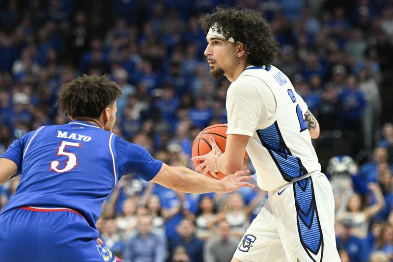 Dec 4, 2024; Omaha, Nebraska, USA; Creighton Bluejays guard Pop Isaacs (2) dribbles against Kansas Jayhawks guard Zeke Mayo (5) during the second half at CHI Health Center Omaha. Mandatory Credit: Steven Branscombe-Imagn Images