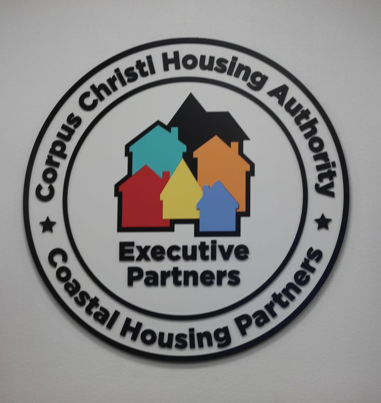 The Corpus Christi Housing Authority's emblem is shown above its board room dais.