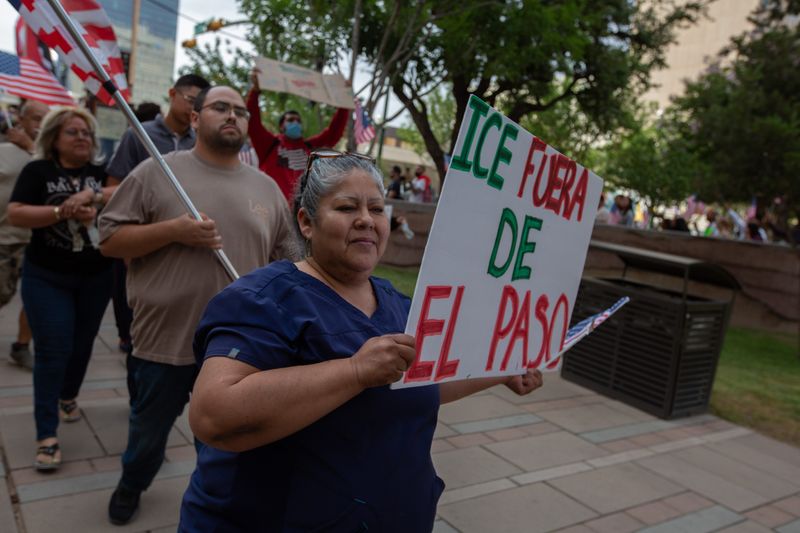 A woman carries a sign calling for ICE to leave El Paso during a vigil in solidarity with Los Angeles protests at San Jacinto Plaza in Downtown El Paso, Texas, on June 10.