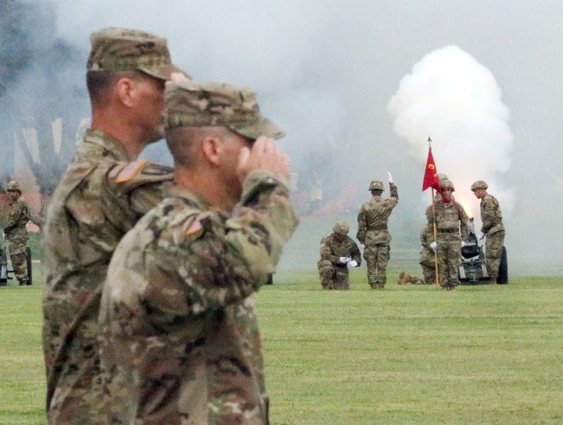 Incoming and outgoing commanders of the 1st Armored Division and Fort Bliss salute as a gun salute takes place during the change of command ceremony at Fort Bliss.