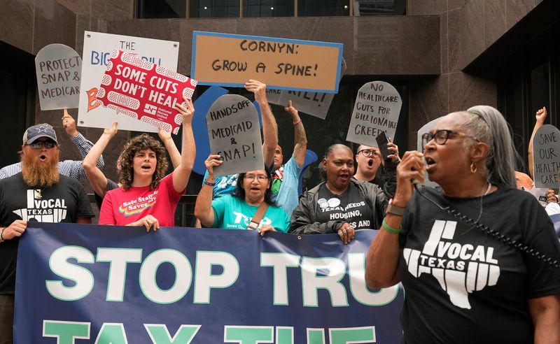 Carolyn Williams protests the Big Beautiful Bill outside the office of Sen. John Cornyn in Austin, Thursday, June 12, 2025. A group of protesters organized by Vocal Texas urged Sen. Cornyn to vote no on the bill.