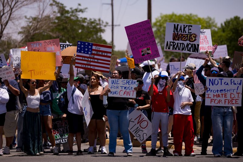 Protesters in El Paso held signs and American flags during a No Kings demonstration at Edgemere Park on Saturday, June 14, 2025. The event was part of a national movement opposing authoritarianism and recent immigration enforcement actions.