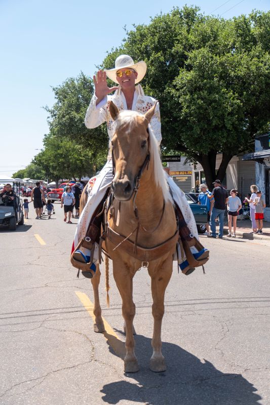 Guy Bell, dressed in a rhinestone-studded outfit, waves to the crowd while riding horseback down Sixth Avenue during the Route 66 Festival finale in Amarillo on June 14.