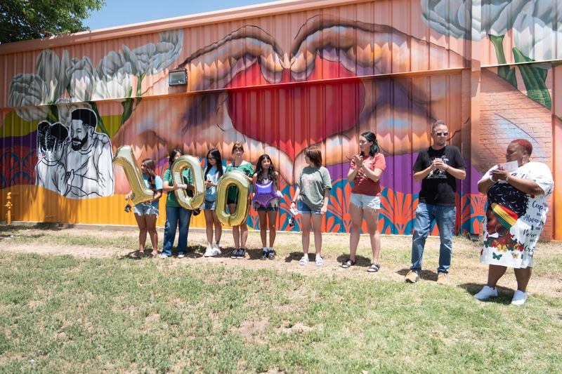 Melodie Graves, executive director of the Amarillo United Citizens Forum, joins Shawn Kennedy, executive director of Blank Spaces, and mural artists from Blank Spaces to celebrate the unveiling of the group’s 100th mural on June 19.