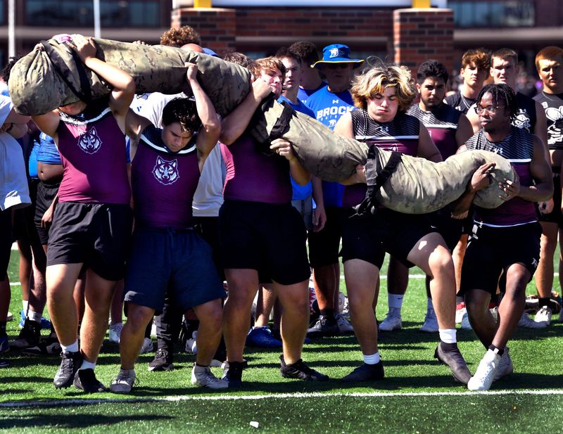 The Davenport High School team struggles to lift The Worm, a 10-foot bag filled with sand, to their shoulders before running it down the field and back during the State Lineman Challenge at Hardin-Simmons University on June 21, 2025. The competition pitted dozens of high school football lineman squads from across the state against each other through a series of contests designed to test strength, teamwork and stamina.