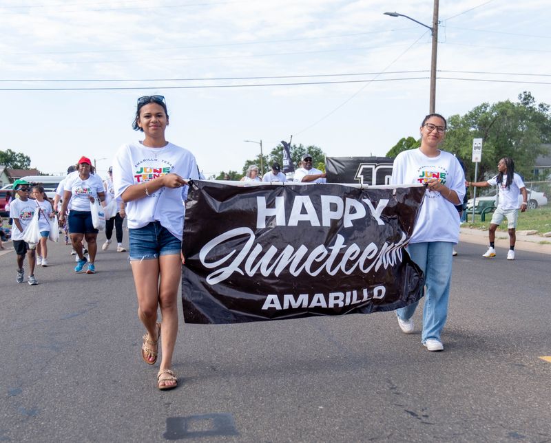 Parade participants carry a “Happy Juneteenth Amarillo” banner down Hughes Street during the city’s Juneteenth parade on June 21.