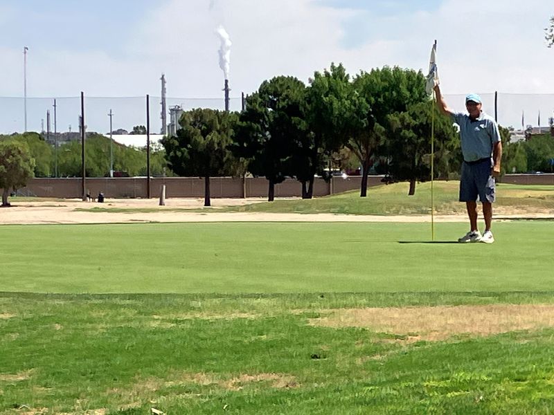 Ascarate Golf Course pro Mike Smith hols the pin on hole No. 5, a 251-yard par 3.
