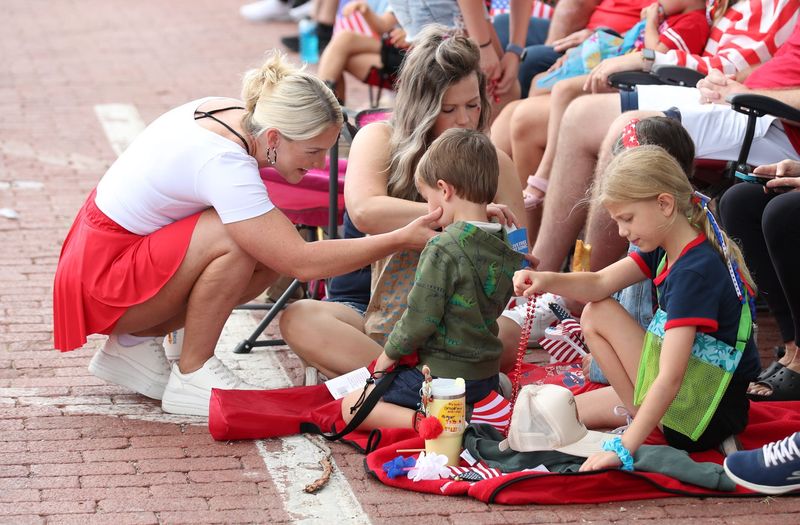 Jarisa Larsen wipes a smudge off the face of her 4-year-old son Ledger Larson during the parade. The 4th on Broadway parade took place Friday morning in Lubbock.