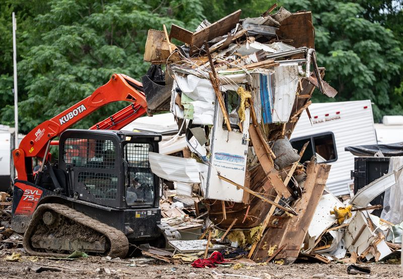 Machinery demolishes an RV to move it into a dumpster while helping clean-up efforts at GoodWater RV Park near Georgetown, July 9, 2025 after devastating flash flooding swept through the area on July 5.