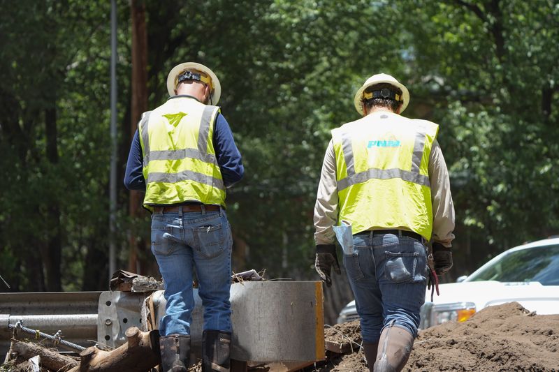 City workers work on clearing and reporting major damage from the flood in Ruidoso, New Mexico on July 9, 2025.