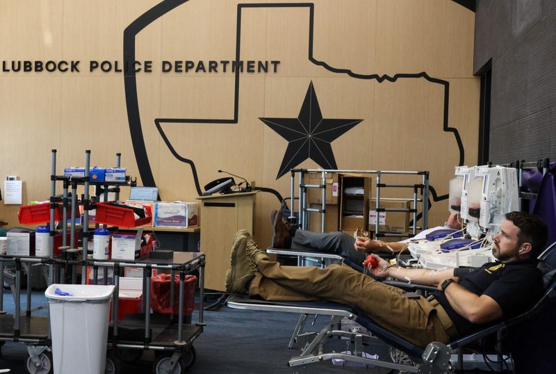 Lubbock Police Department officers sit as they give double red cell donation at LPD Headquarters as part of the 10th Annual Battle of the Badges blood drive on July 15, 2025 in Lubbock, Texas. This type of donation takes two pints of blood instead of the normal one pint.