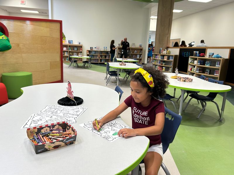 Kindergartner Jayla Fulbright explores the library at the new London Primary School on July 18.