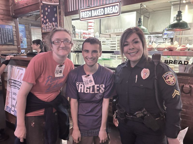 Special Olympics athletes Priscilla Fickling and Riley Dunn stand with APD Cpl. Carmela Ogden at the Tip-A-Cop fundraiser, held July 24 at Texas Roadhouse. The event raised close to $5,000 to help local Special Olympics kids to achieve their goals. Amarillo and Canyon police departments, along with athletes and Texas Roadhouse waitresses and waiters, took up donations during the event.
