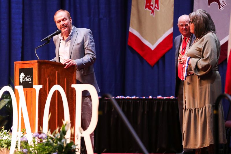 Clarence Goodnight's grandchildren, Greg and Diane (far right) speak on his behalf during the Lubbock ISD athletics hall of honor induction ceremony, Saturday, July 26, 2025, at the Lubbock Memorial Civic Center.