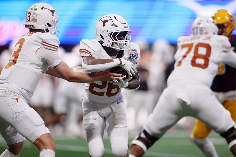 Jan 1, 2025; Atlanta, GA, USA; Texas Longhorns quarterback Quinn Ewers (3) fakes a handoff to running back Quintrevion Wisner (26) against the Arizona State Sun Devils during the second half of the Peach Bowl at Mercedes-Benz Stadium. Mandatory Credit: Brett Davis-Imagn Images