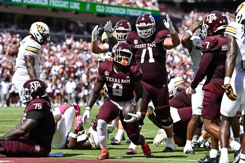Oct 5, 2024; College Station, Texas, USA; Texas A&M Aggies running back Le'Veon Moss (8) reacts after scoring a touchdown in the first half against the Missouri Tigers at Kyle Field. Mandatory Credit: Maria Lysaker-Imagn Images.