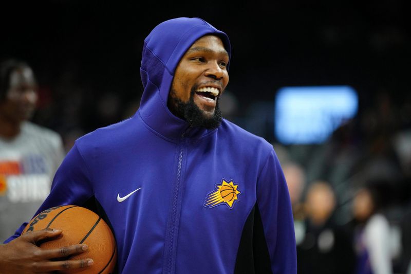 Suns forward Kevin Durant laughs as he takes the court to play the Raptors prior to a game at the Footprint Center.