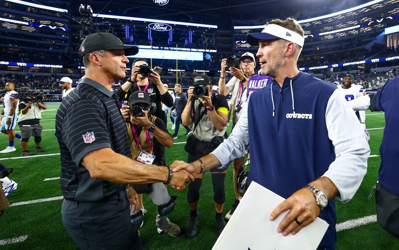 Aug 16, 2025; Arlington, Texas, USA; Dallas Cowboys head coach Brian Schottenheimer (right) shakes hands with Baltimore Ravens head coach John Harbaugh after the game at AT&T Stadium. Mandatory Credit: Kevin Jairaj-Imagn Images