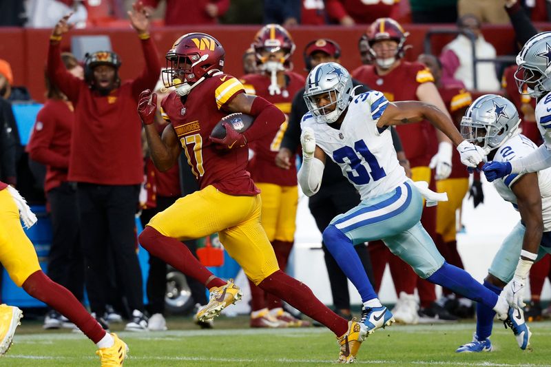 Nov 24, 2024; Landover, Maryland, USA; Washington Commanders wide receiver Terry McLaurin (17) scores a touchdown in the final minute of the fourth quarter as Dallas Cowboys cornerback Josh Butler (31) chases at Northwest Stadium. Mandatory Credit: Geoff Burke-Imagn Images