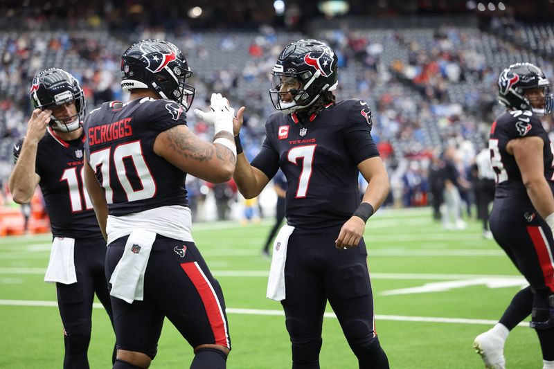 Jan 11, 2025; Houston, Texas, USA; Houston Texans guard Juice Scruggs (70) and quarterback C.J. Stroud (7) warm up prior to the game against the Los Angeles Chargers in an AFC wild card game at NRG Stadium. Mandatory Credit: Troy Taormina-Imagn Images