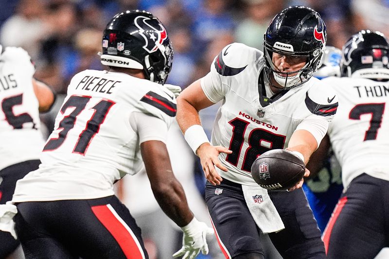 Houston Texans quarterback Graham Mertz (18) hands the ball to running back Dameon Pierce (31) against Detroit Lions during the first half at Ford Field in Detroit on Saturday, August 23, 2025.
