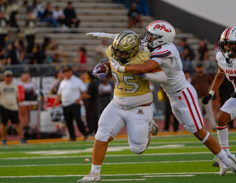 Austin’s Roberto Flores runs as an El Paso High defender attempts to bring him down during the Battle of the Claw rivalry game on Aug. 29, 2025, at Austin High School in El Paso, Texas.