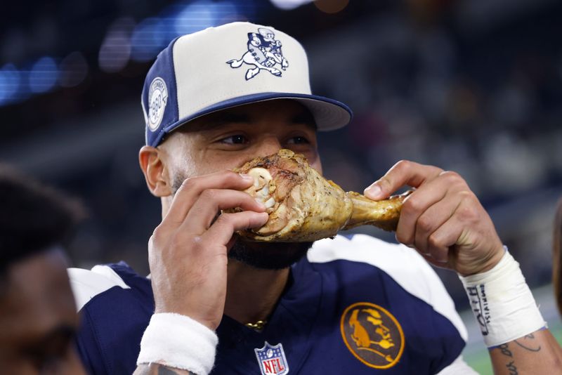 ARLINGTON, TEXAS - NOVEMBER 23: Dak Prescott #4 of the Dallas Cowboys takes a bite out of a turkey leg after a win over the Washington Commanders at AT&T Stadium on November 23, 2023 in Arlington, Texas. (Photo by Ron Jenkins/Getty Images)