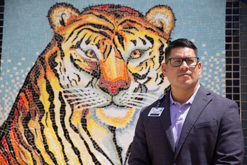 Carroll High School Principal Robert Arredondo poses for a portrait in front of a tiger mural at the campus on Sept. 5. The Corpus Christi Independent School District announced Nov. 21 that Arredondo will leave his position in mid-December.