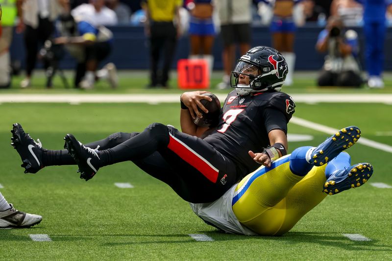 Sep 7, 2025; Inglewood, California, USA; Los Angeles Rams linebacker Byron Young (0) sacks Houston Texans quarterback C.J. Stroud (7) during the second quarter at SoFi Stadium. Mandatory Credit: Kiyoshi Mio-Imagn Images
