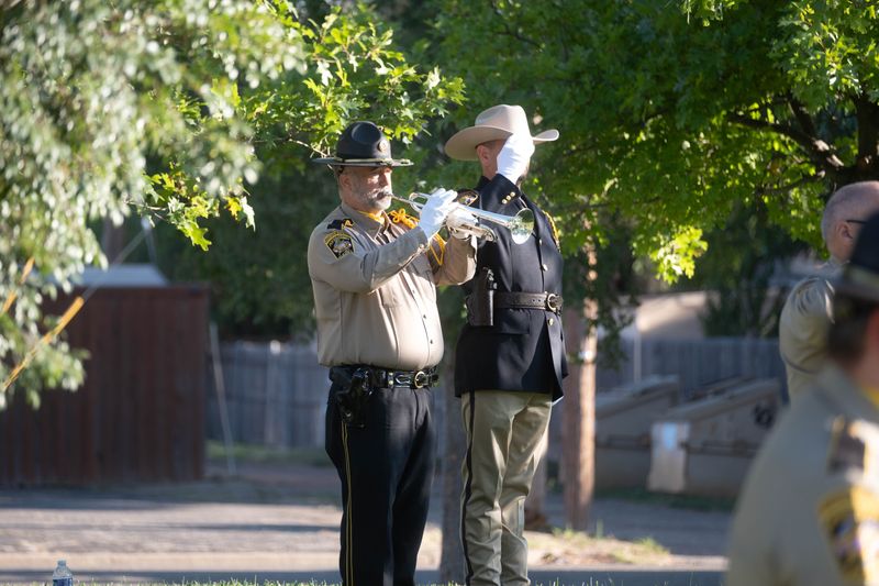A member of the Potter County Sheriff’s Office Honor Guard plays “Taps” as an officer salutes during Thursday’s 9/11 remembrance ceremony at the Texas Panhandle War Memorial Center in Amarillo.