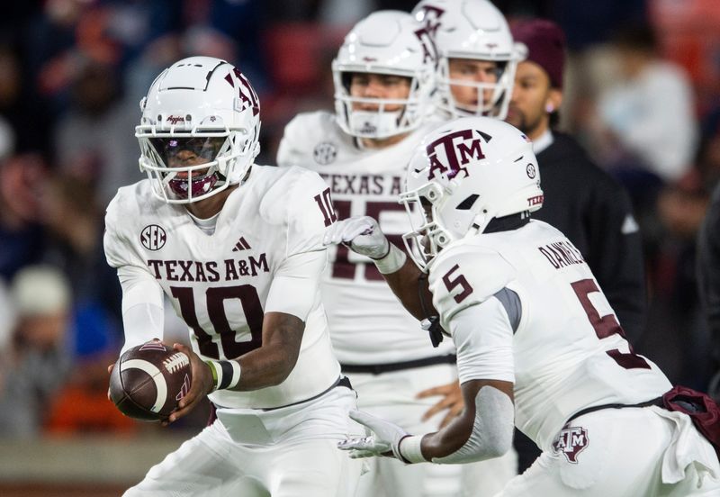 Texas A&M quarterback Marcel Reed hands the ball off to running back Amari Daniels during warmups before the Aggies' game against Auburn on Nov. 23, 2024, in Auburn, Ala.