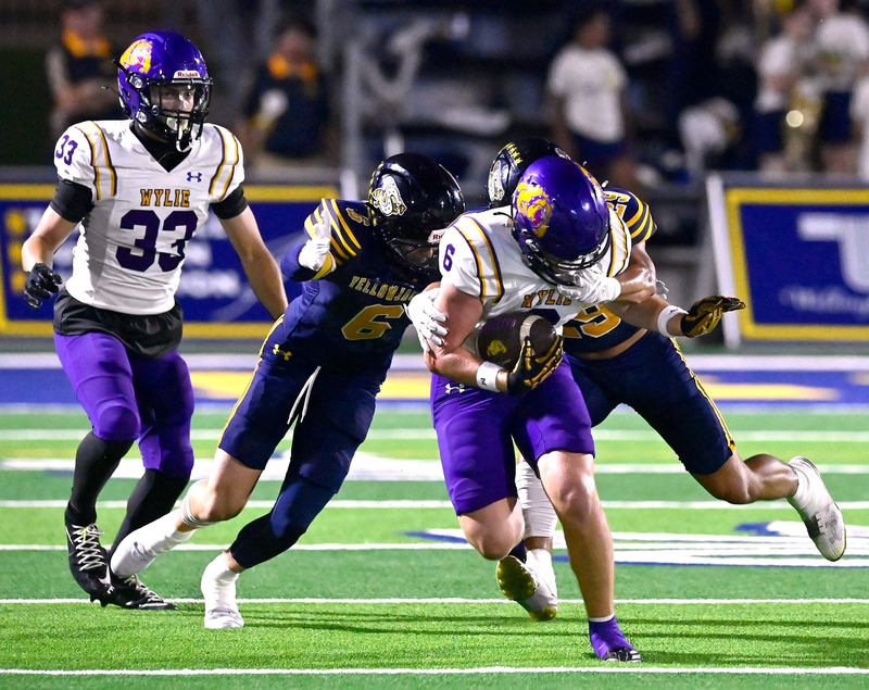 Wylie wide receiver Wyatt Kidman is tackled by Stephenville defenders during Friday’s game at Art Briles Stadium in Stephenville Sept. 19, 2025. Final score was 52-13, Stephenville.