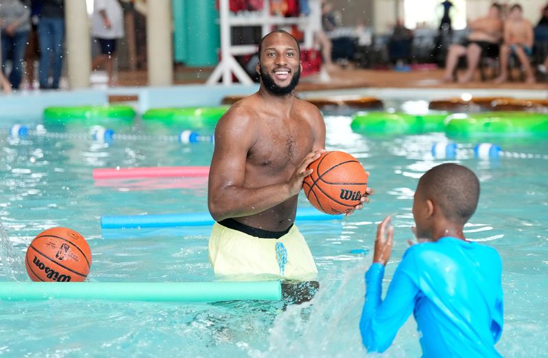 Houston Rockets’ Josh Okogie shoots baskets from the pool with kids from the Boys and Girls Club during the Great Wolf Lodge Texas Gulf Coast’s first birthday celebration, Wednesday, Sept. 24, 2025, in Webster.