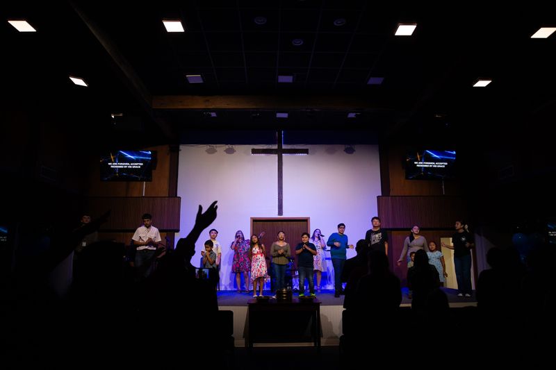 Congregants worship as children sing a hymn at First Christian Church of Alice on Sept. 27. The church reopened a year after being closed due to major water damage.