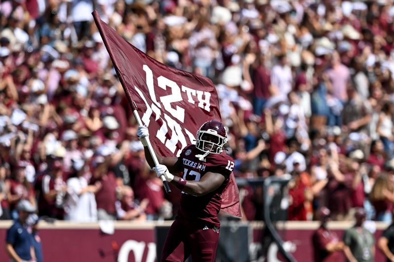 Sep 27, 2025; College Station, Texas, USA; Texas A&M Aggies defensive end Nana Boadi-Owusu (12) runs out with the 12th man flag prior to the game against the Auburn Tigers at Kyle Field. Mandatory Credit: Maria Lysaker-Imagn Images
