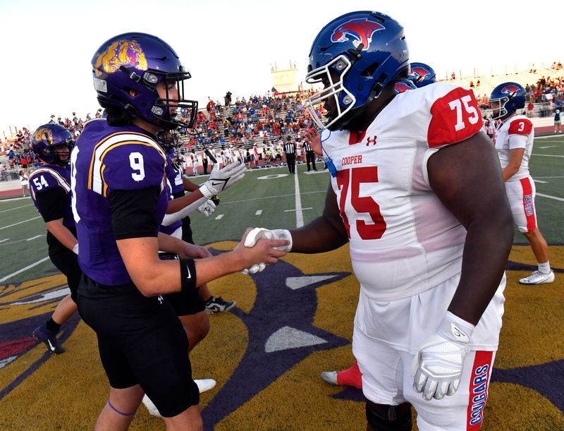 Wylie High School’s Michael Pena-Perez (left) shakes hands with Cooper High School’s Kayden Bryan at the start of Friday’s game at Bulldog Stadium in Abilene Oct. 3, 2025. Final score was 29-22, Wylie.