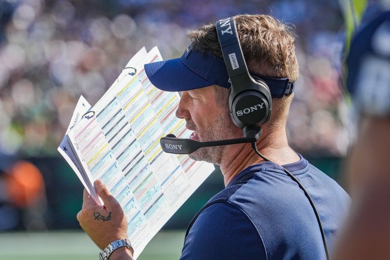 Oct 5, 2025; East Rutherford, New Jersey, USA; Dallas Cowboys head coach Brian Schottenheimer looks over his play sheet against the New York Jets during the first half at MetLife Stadium. Mandatory Credit: Robert Deutsch-Imagn Images