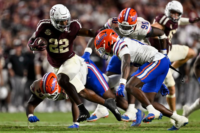 Oct 11, 2025; College Station, Texas, USA; Texas A&M Aggies running back Ej Smith (22) stiff arms Florida Gators defensive back Micheal Caraway Jr. (16) during the fourth quarter at Kyle Field. Mandatory Credit: Maria Lysaker-Imagn Images