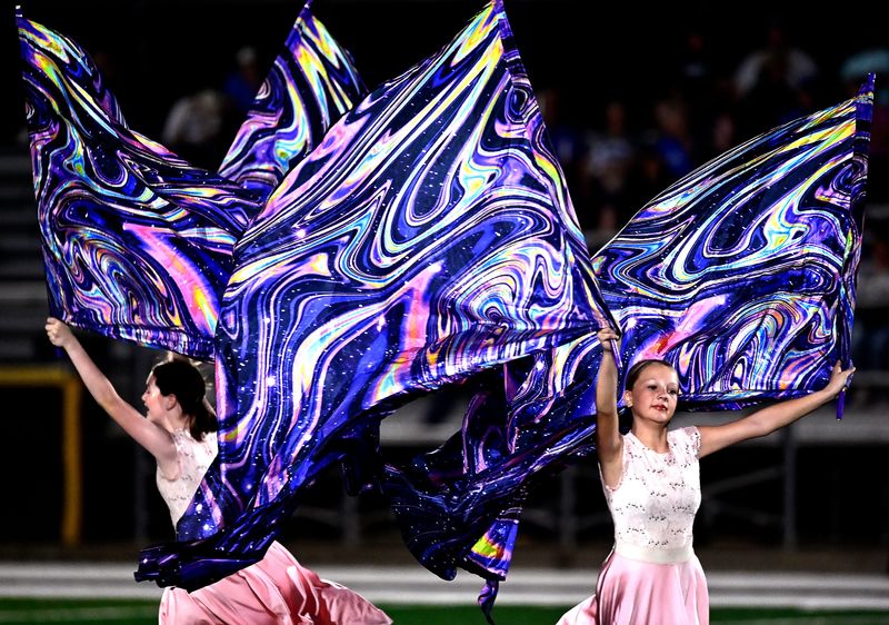 Evalynn Burns (left) and Daisy McKissick perform with the Cisco High School Color Guard during the Mighty Lobo Band’s halftime performance during Friday’s game against Stamford Oct. 10, 2025.