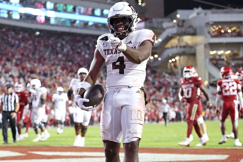Oct 18, 2025; Fayetteville, Arkansas, USA; Texas A&M Aggies running back Rueben Owens II (4) celebrates after rushing for a touchdown in the fourth quarter against the Arkansas Razorbacks at Donald W. Reynolds Razorback Stadium. Mandatory Credit: Nelson Chenault-Imagn Images
