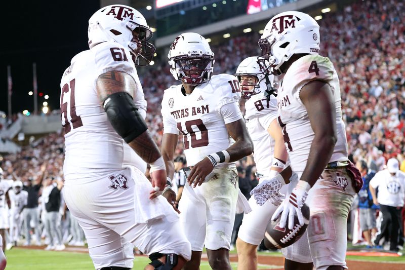 Oct 18, 2025; Fayetteville, Arkansas, USA; Texas A&M Aggies quarterback Marcel Reed (10) celebrates with running back Rueben Owens II (4) after Owner rushed for a touchdown in the fourth quarter against the Arkansas Razorbacks at Donald W. Reynolds Razorback Stadium. Mandatory Credit: Nelson Chenault-Imagn Images