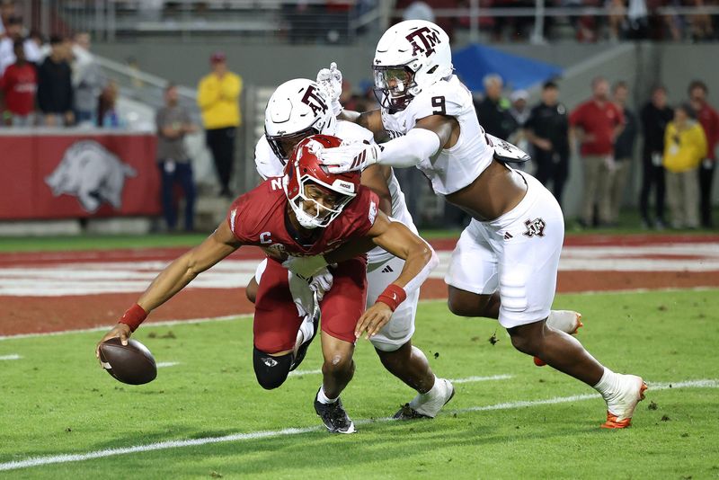 Oct 18, 2025; Fayetteville, Arkansas, USA; Texas A&M Aggies defensive end Dayon Hayes (50) sacks Arkansas Razorbacks quarterback Taylen Green (10) during the fourth quarter as Aggies defensive end Cashius Howell (9) closes in at Donald W. Reynolds Razorback Stadium. Mandatory Credit: Nelson Chenault-Imagn Images
