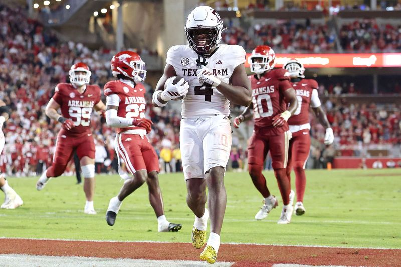 Oct 18, 2025; Fayetteville, Arkansas, USA; Texas A&M Aggies running back Rueben Owens II (4) rushes for a touchdown in the fourth quarter against the Arkansas Razorbacks at Donald W. Reynolds Razorback Stadium. Mandatory Credit: Nelson Chenault-Imagn Images
