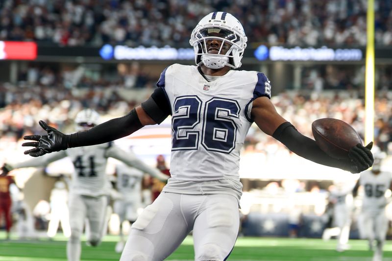 Oct 19, 2025; Arlington, Texas, USA; Dallas Cowboys cornerback Daron Bland (26) carries the ball after an interception for a touchdown against the Washington Commanders during the third quarter of the game at AT&T Stadium. Mandatory Credit: Kevin Jairaj-Imagn Images
