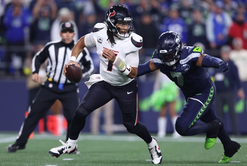 Oct 20, 2025; Seattle, Washington, USA; Houston Texans quarterback C.J. Stroud (7) is chased by Seattle Seahawks linebacker Uchenna Nwosu (7) during the first quarter at Lumen Field. Mandatory Credit: Kevin Ng-Imagn Images