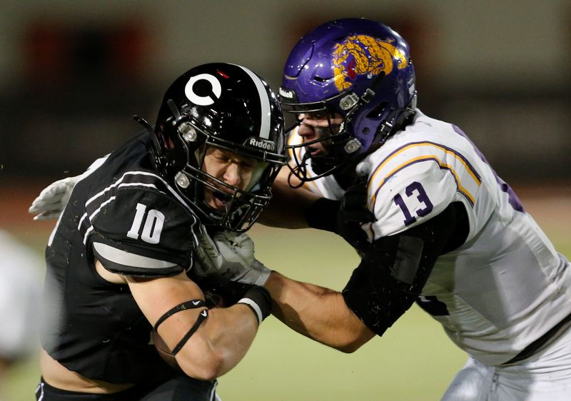 Lubbock-Cooper's Jathan Caraway (10) is tackled by Abilene Wylie's Bo Kates in a District 2-5A Division II football game Friday, Oct. 31, 2025, at Pirate Stadium in Woodrow.
